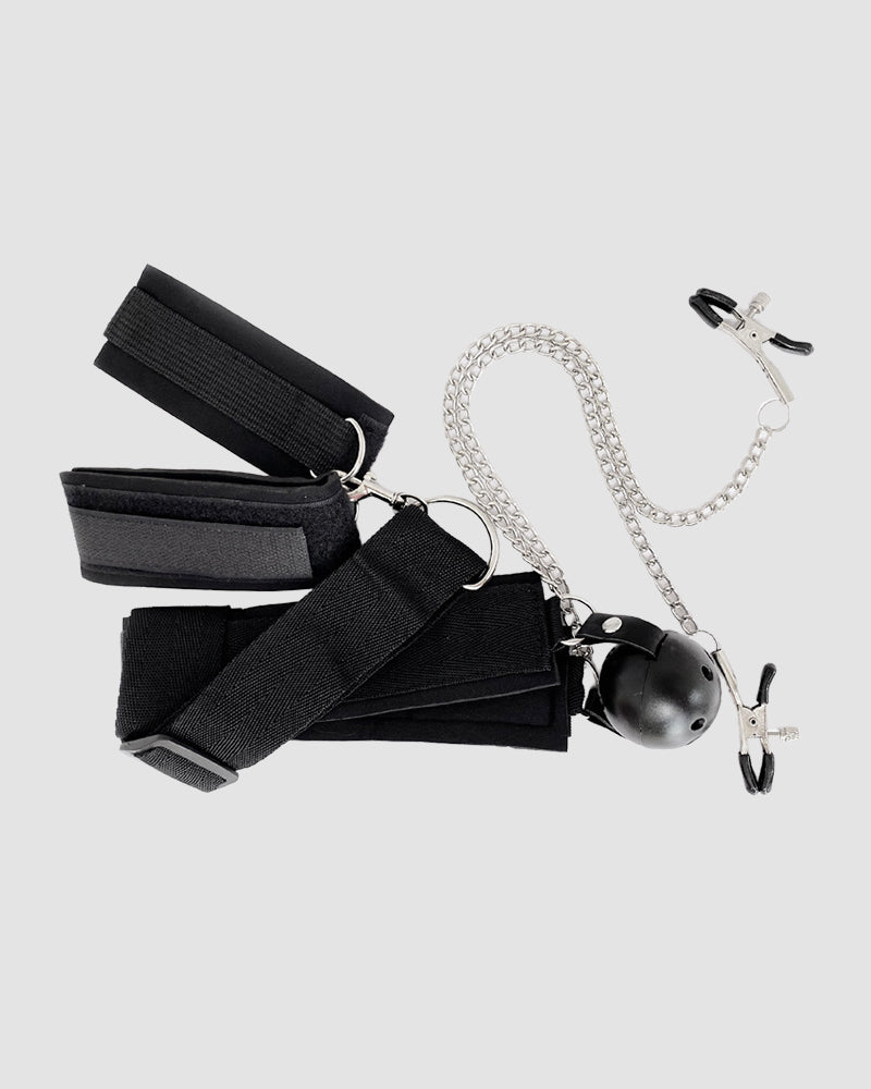 Black SM bondage set with wrist cuffs, ball gag, nipple clamps, and chain for intimate exploration.