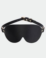 Black leather sunshade eye mask with adjustable strap and gold hardware for intimate sessions.