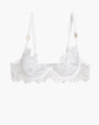 White embroidered lace bra with adjustable straps and underwire, featuring a delicate floral design.
