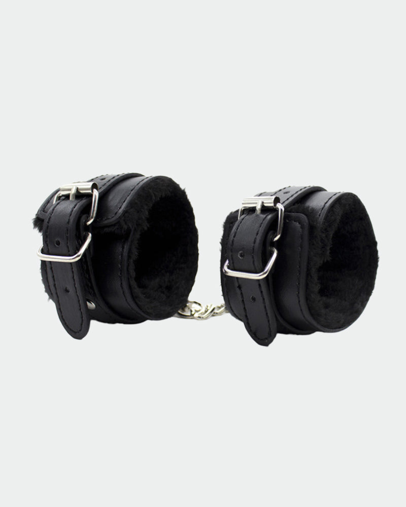 Black leather plush wrist handcuffs with silver buckles for intimate role play and sensual moments.