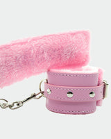 Pink plush wrist handcuffs with leather straps and silver hardware for intimate role play
