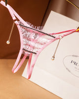 Pink crotchless thong with floral lace, pearl pendant, and low waist. Sexy lingerie.