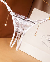 White crotchless thong with floral lace, pearl pendant, and low waist. Sexy lingerie.