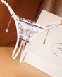 White crotchless thong with floral lace, pearl pendant, and low waist. Sexy lingerie.