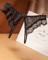 Black lace crotchless thong with floral design, low waist, and Prada shopping bag background